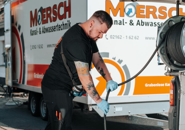 Handwerker mit Schlauch bei Kanalreinigung in Mönchengladbach