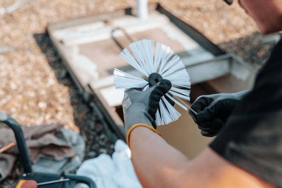 Hand hält Bürste für Abflussreinigung