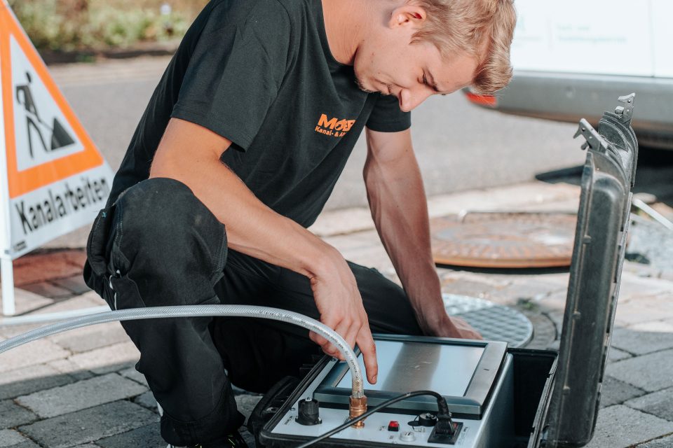 Mitarbeiter bei Rohrreinigung eines verstopften Abflusses in Mönchengladbach